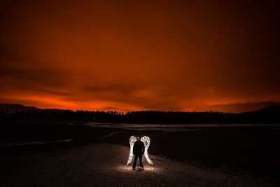 Two men on field against dramatic sky