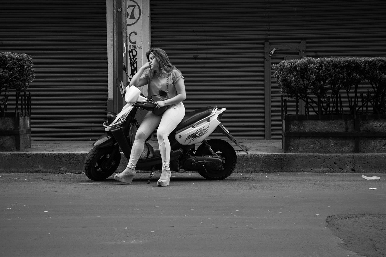 WOMAN RIDING MOTORCYCLE ON BICYCLE