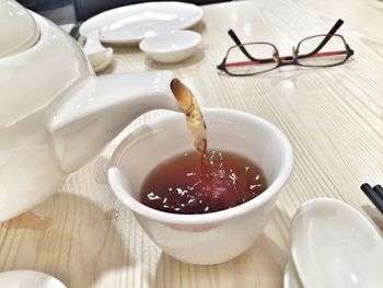 Close-up of chinese tea being poured in cup on table