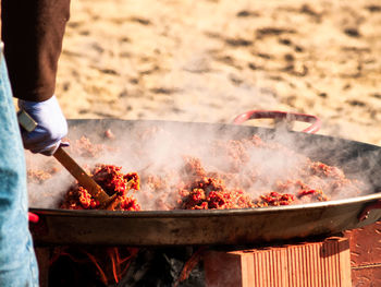 Midsection of man preparing food on barbecue grill