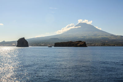 Scenic view of sea and mountains against sky