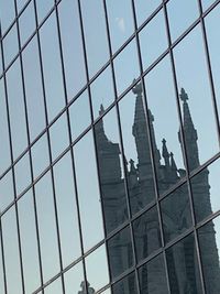 Low angle view of glass building against sky