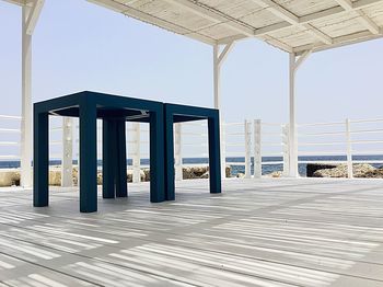 Footpath by sea against clear blue sky