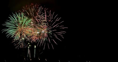Low angle view of firework display at night