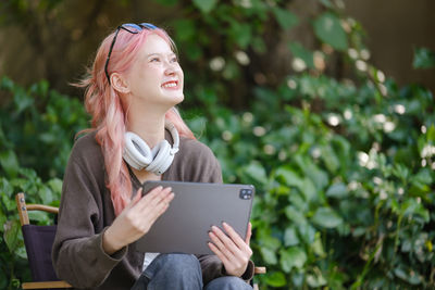 Young woman using laptop while sitting outdoors
