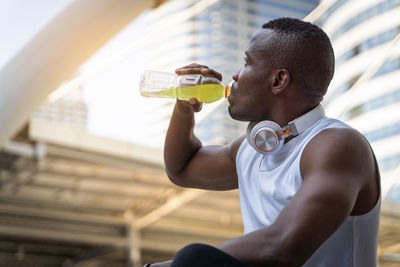 Side view of young man drinking water