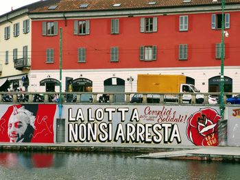 Graffiti on building by river in city