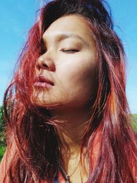 Close-up of young woman against sky