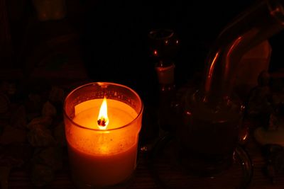 Close-up of lit tea light candles in darkroom