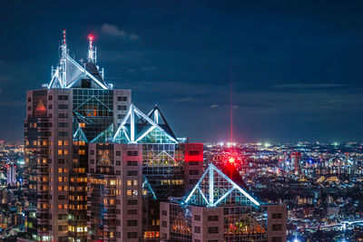 Illuminated cityscape against sky at night