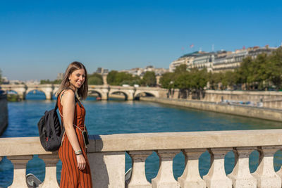 Portrait of smiling woman standing against sky