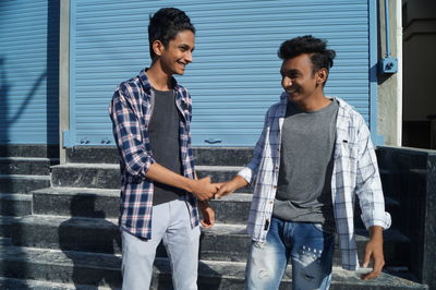 Portrait of young man standing against wall