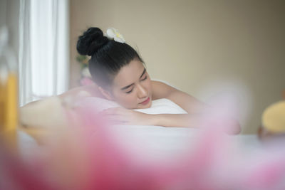 Young woman lying on massage table in spa