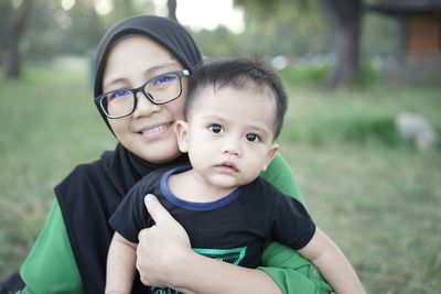 Portrait of cute boy with mother on field