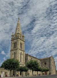 Low angle view of church against cloudy sky
