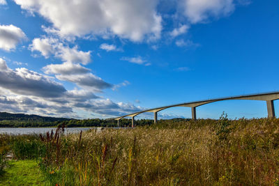 Arch bridge on field against sky