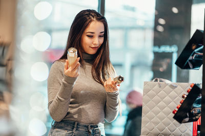 Young woman using mobile phone while standing outdoors