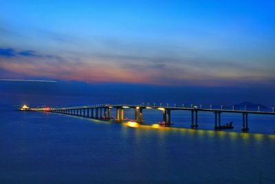 Bridge over calm sea against sky