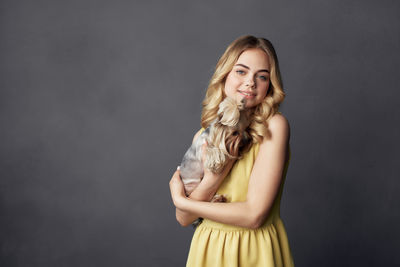 Portrait of a smiling young woman against gray background