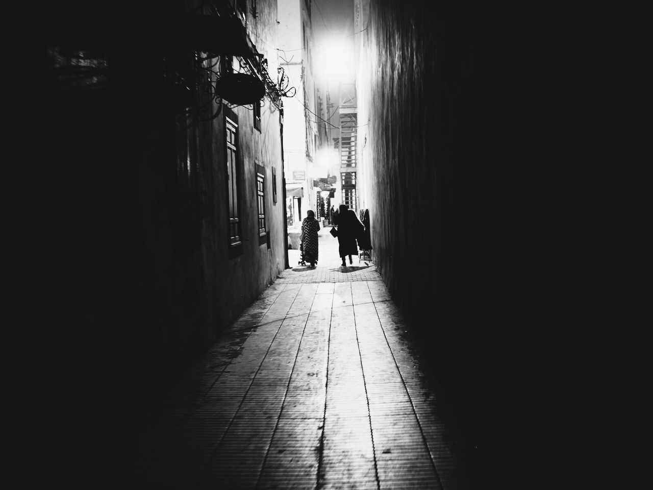 MAN WALKING ON WALKWAY IN CITY