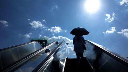 Low angle view of man standing on staircase against sky