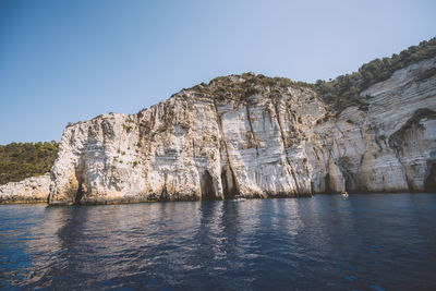 Scenic view of sea and mountains against clear sky