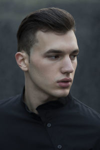 Close-up of thoughtful young man standing outdoors