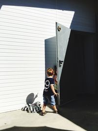 Kids playing hide and seek by door on sunny day