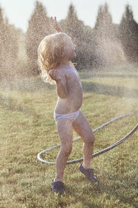 Cheerful shirtless girl enjoying at yard