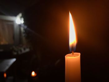 Close-up of burning candle in a dark room