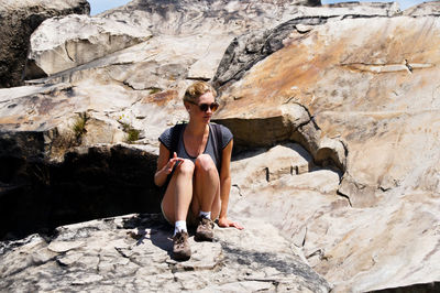 Young woman sitting on rock