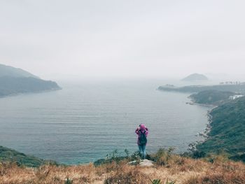 Person standing beside river