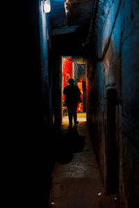 A tourist walking through narrow streets of varanasi at night.