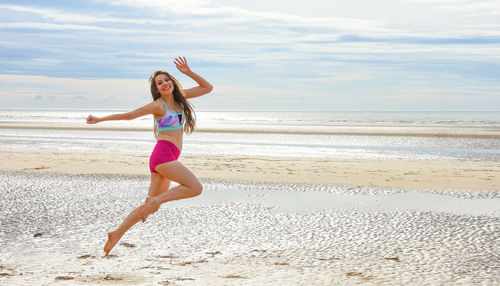 Full length of woman on beach against sky