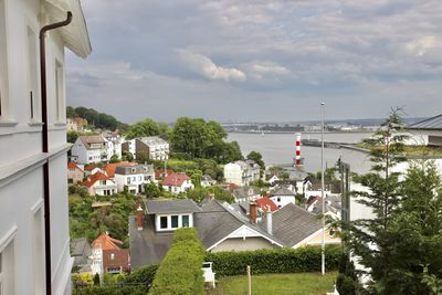 High angle view of townscape by sea against sky