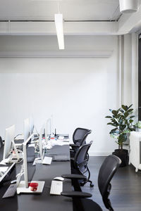 Empty chairs with desktop computers at office