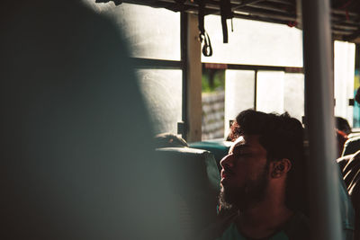 Portrait of young man looking through window
