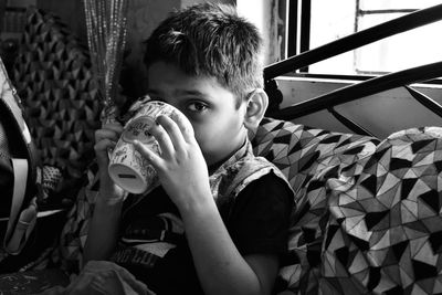 A boy drinking milkshake in a big cup