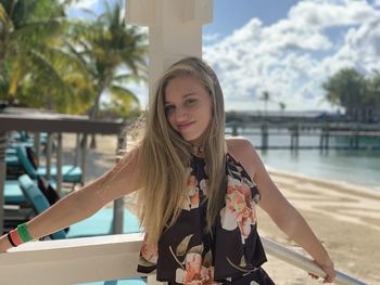 Portrait of teenage girl standing by railing