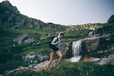 Full length of woman standing on cliff against clear sky