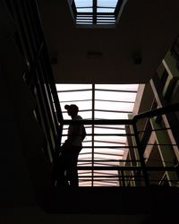 Silhouette person walking on staircase in building