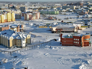 High angle view of snow covered buildings in city