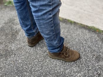 Low section of man standing on road