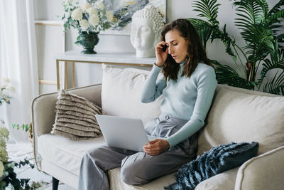 Beautiful woman on the couch working on a laptop.