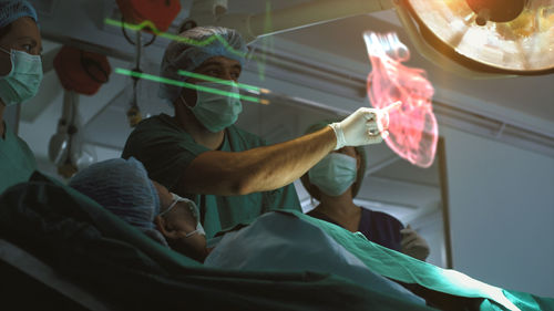 Surgeon diagnosing a senior woman's heart problem via a holographic body scan