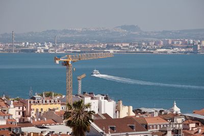 High angle view of city by sea against sky