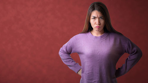 Portrait of woman standing against wall