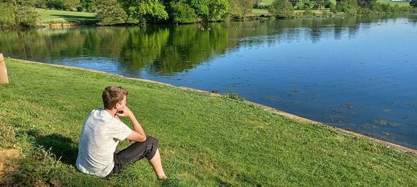 Full length of young woman standing by lake