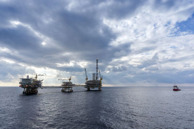 An anchor handling tug boat maneuvering at oil platform complex vicinity at offshore oil field 