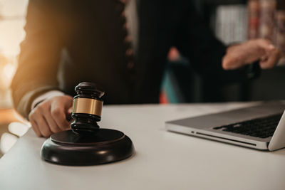 Midsection of man using laptop on table